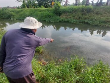 TEWAS: Warga menunjukkan lokasi tewasnya korban di Sungai Brantas, Kota Probolinggo. (foto: Hafiz Rozani)
