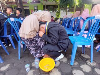 TRADISI: Prosesi basuh kaki orang tua yang dilakukan oleh siswa kelas 9 SMPN 8 Kota Probolinggo. (foto: Hafiz Rozani).
