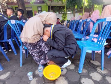 TRADISI: Prosesi basuh kaki orang tua yang dilakukan oleh siswa kelas 9 SMPN 8 Kota Probolinggo. (foto: Hafiz Rozani).
