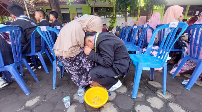 TRADISI: Prosesi basuh kaki orang tua yang dilakukan oleh siswa kelas 9 SMPN 8 Kota Probolinggo. (foto: Hafiz Rozani).

