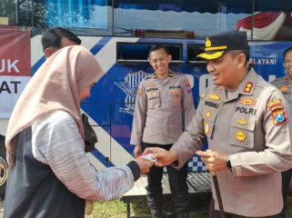 INOVASI: Kapolres Probolinggo, AKBP Wisnu Wardhana, memberikan SIM pada Anatasya Agita, salah seorang warga yang mengurus perpanjangan SIM. (foto: Ali Ya'lu).
