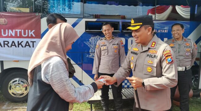 INOVASI: Kapolres Probolinggo, AKBP Wisnu Wardhana, memberikan SIM pada Anatasya Agita, salah seorang warga yang mengurus perpanjangan SIM. (foto: Ali Ya'lu).
