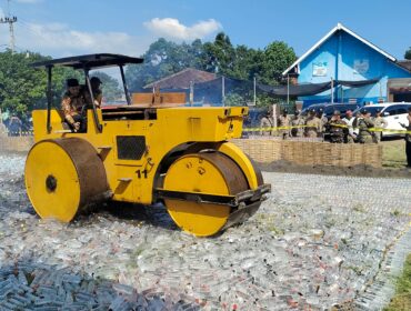 TEGAS: Bupati Probolinggo, Gus Haris, saat menghancurkan puluhan ribu botol miras menggunakan alat berat. (foto: Ali Ya'lu).