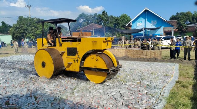 TEGAS: Bupati Probolinggo, Gus Haris, saat menghancurkan puluhan ribu botol miras menggunakan alat berat. (foto: Ali Ya'lu).