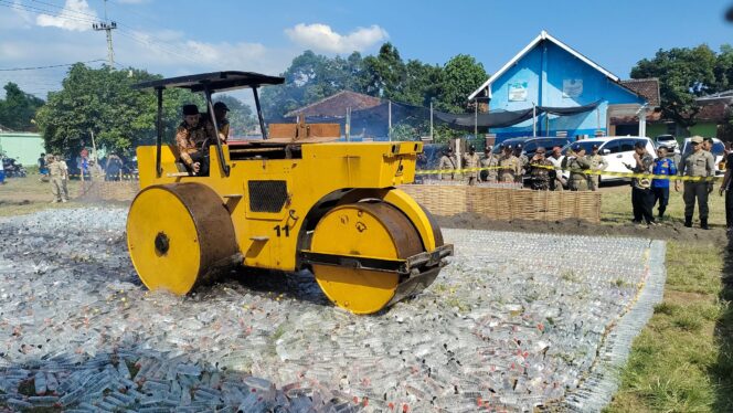 
					TEGAS: Bupati Probolinggo, Gus Haris, saat menghancurkan puluhan ribu botol miras menggunakan alat berat. (foto: Ali Ya'lu).