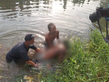 HEBOH: Polisi dibantu warga evakuasi jasad korban dari Sungai Brantas, Kota Probolinggo. (foto: Hafiz Rozani).
