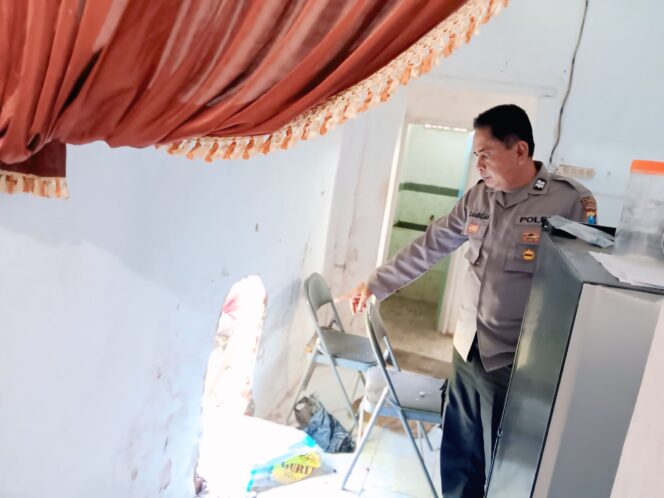 
					Seorang polisi dari Polsek Grati menunjuk lubang di tembok dapur SDN Kalipang 1, Kecamatan Grati, Kabupaten Pasuruan, yang dibobol pencuri. (Foto: Moh. Rois)