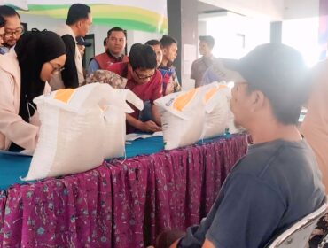 DISTRIBUSI: Warga antre untuk menerima bantuan beras di kantor Kelurahan Kebonsari, Kecamatan Sumbersari, Kabupaten Jember  Kamis (17/7/25) siang. (Foto: M. Abd Rozaq Mubarok) 