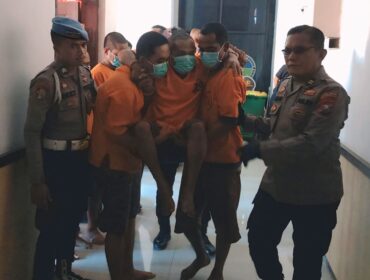 DITEMBAK: Pelaku perampokan (digendong) saat dibawa mengikuti rilis di Polres Probolinggo Kota. (foto: Hafiz Rozani).
