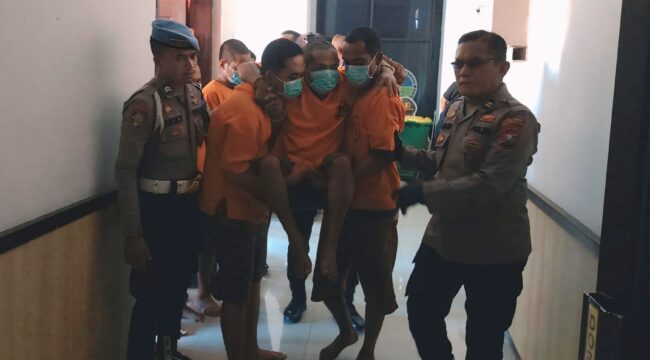 DITEMBAK: Pelaku perampokan (digendong) saat dibawa mengikuti rilis di Polres Probolinggo Kota. (foto: Hafiz Rozani).
