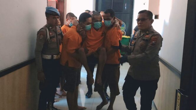 
					DITEMBAK: Pelaku perampokan (digendong) saat dibawa mengikuti rilis di Polres Probolinggo Kota. (foto: Hafiz Rozani).
