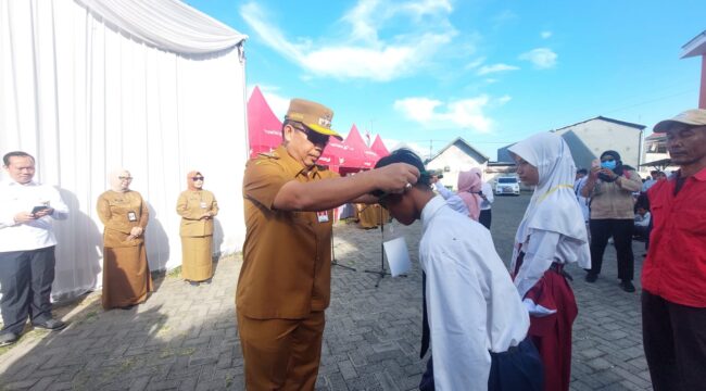 PENGENALAN: Wali Kota Probolinggo, dr. Aminuddin, mengalungkan identitas siswa Sekolah Rakyat, Senin (14/7/25) pagi. (foto: Hafiz Rozani).