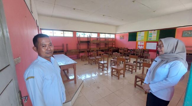 KOSONG: Guru dan Kepala SDN Warujinggo 2 Leces Probolinggo, berada di ruang kelas yang kosong tanpa siswa. (foto: Hafiz Rozani).