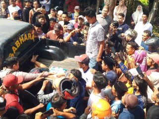 TERTANGKAP: Dua pelaku curanmor di masjid Desa Sentul, Kecamatan Gading, Kabupaten Probolinggo, saat diangkut ke mobil polisi. (foto: Ali Ya'lu).
