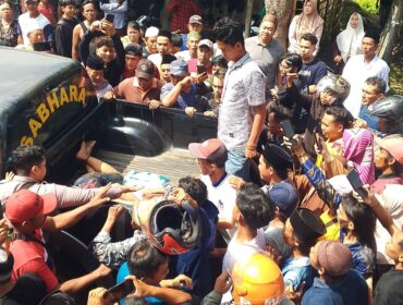 TERTANGKAP: Dua pelaku curanmor di masjid Desa Sentul, Kecamatan Gading, Kabupaten Probolinggo, saat diangkut ke mobil polisi. (foto: Ali Ya'lu).
