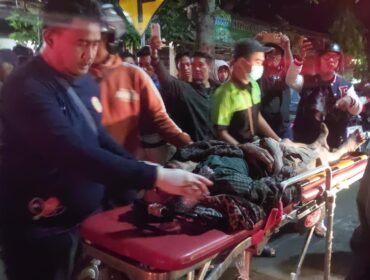 LAKA: Warga saat mengevakuasi korban kecelakaan di Jalan Gubernur Suryo, Kota Probolinggo ke mobil ambulans. (foto: Hafiz Rozani).
