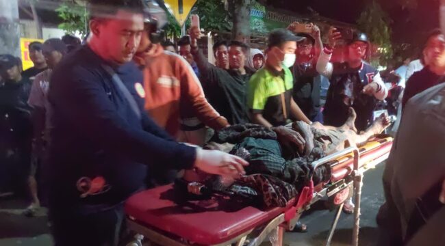 LAKA: Warga saat mengevakuasi korban kecelakaan di Jalan Gubernur Suryo, Kota Probolinggo ke mobil ambulans. (foto: Hafiz Rozani).
