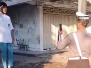 Seorang pelajar menyanyikan lagu Indonesia Raya di pinggir jalan usai terjaring Operasi Patuh Semeru 2025 di Pasuruan.