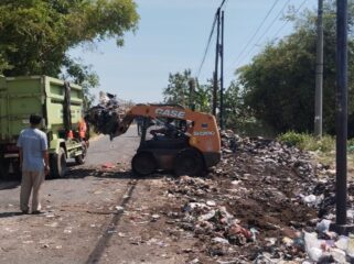 DIBERSIHKAN: Alat berat dan truk dikerahkan untuk membersihkan sampah di batas Kota Probolinggo. (foto: istimewa)