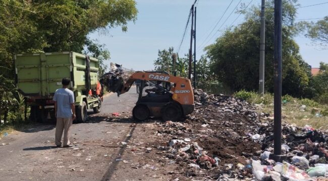DIBERSIHKAN: Alat berat dan truk dikerahkan untuk membersihkan sampah di batas Kota Probolinggo. (foto: istimewa)