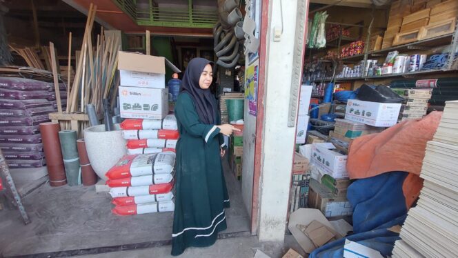 
					KEMALINGAN: Istri korban  Abdurrahman, menunjukkan pintu toko bangunan di Kota Probolinggo, yang kurang rapat saat pelaku masuk. (foto: Hafiz Rozani).
