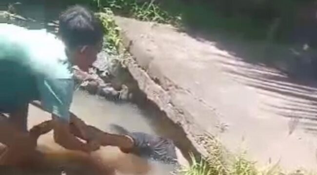MENINGGAL: Proses evakuasi jenazah Moh. Guntur Firmansyah, asal Desa Jatiurip, Kecamatan Krejengan, Kabupaten Probolinggo, dari saluran irigasi. (foto: Ali Ya'lu).