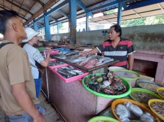 MAHAL: Pedagang ikan di TPI Mayangan Kota Probolinggo, Tomi Santoso saat melayani pembeli ikan. (foto: Hafiz Rozani).