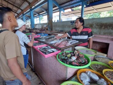 MAHAL: Pedagang ikan di TPI Mayangan Kota Probolinggo, Tomi Santoso saat melayani pembeli ikan. (foto: Hafiz Rozani).