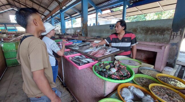 MAHAL: Pedagang ikan di TPI Mayangan Kota Probolinggo, Tomi Santoso saat melayani pembeli ikan. (foto: Hafiz Rozani).