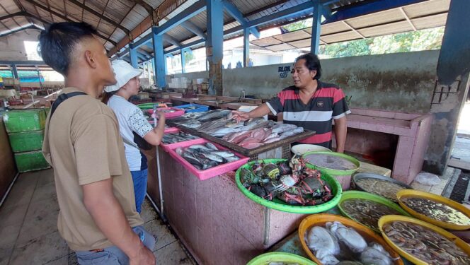 
					MAHAL: Pedagang ikan di TPI Mayangan Kota Probolinggo, Tomi Santoso saat melayani pembeli ikan. (foto: Hafiz Rozani).