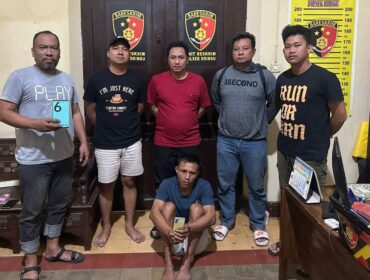DITANGKAP: Nurahmad (duduk dengan memegang ponsel curiannya) usai diamankan oleh anggota Polsek Dringu, Polres Probolinggo. (foto: istimewa)