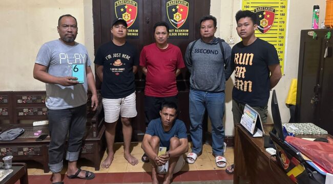DITANGKAP: Nurahmad (duduk dengan memegang ponsel curiannya) usai diamankan oleh anggota Polsek Dringu, Polres Probolinggo. (foto: istimewa)