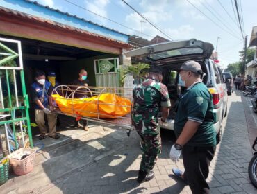 EVAKUASI: Petugas gabungan di Kota Probolinggo mengevakuasi jenasah korban dari dalam rumah ke ambulans. (foto: Hafiz Rozani).
