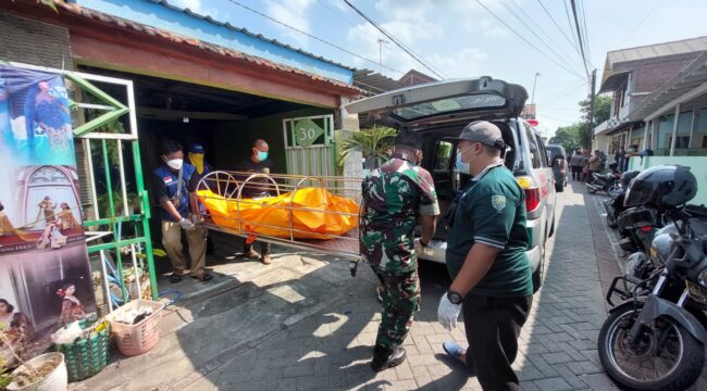 EVAKUASI: Petugas gabungan di Kota Probolinggo mengevakuasi jenasah korban dari dalam rumah ke ambulans. (foto: Hafiz Rozani).
