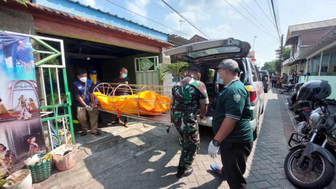 
					EVAKUASI: Petugas gabungan di Kota Probolinggo mengevakuasi jenasah korban dari dalam rumah ke ambulans. (foto: Hafiz Rozani).
