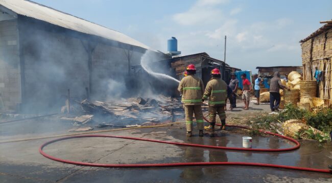 PEMADAMAN: Petugas Damkar Kota Probolinggo saat melakukan pemadaman gudang bajong yang terbakar di Mayangan. (foto: Hafiz Rozani)