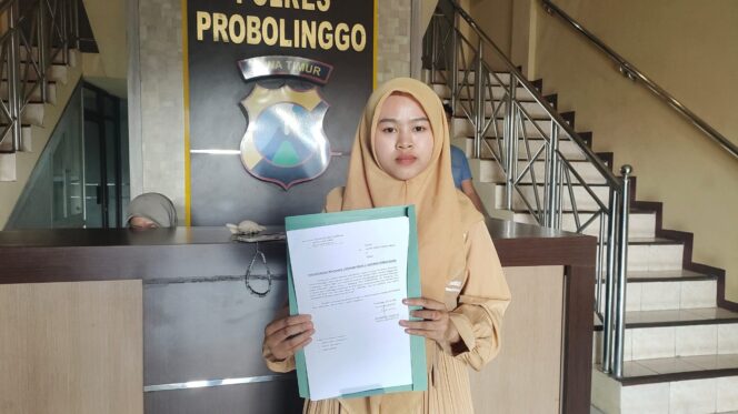 
					LAPORAN: Dita Dwi Angela Putri menunjukkan surat laporannya di Polres Probolinggo, Rabu (30/7/25) siang. (foto: Ali Ya'lu).
