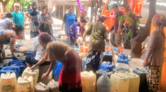 Petugas BPBD Kabupaten Pasuruan menyalurkan air bersih. (Foto: Moh. Rois)
