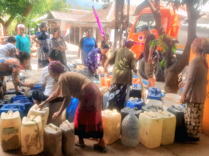 
					Petugas BPBD Kabupaten Pasuruan menyalurkan air bersih. (Foto: Moh. Rois)
