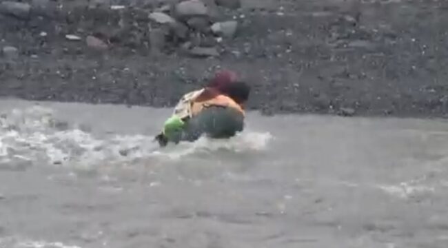 Seorang ayah yang menggendong anaknya terjatuh saat menyeberangi Sungai Regoyo. (Foto: tangkapan layar).

