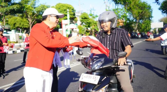 BERBAGI: Wali Kota Probolinggo, dr. Aminuddin, membagikan bendera merah putih kepada para pengguna jalan. (foto: istimewa)