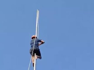 Petugas dari BPBD memanjat tiang dan memperbaiki tali bendera yang putus. (Foto : tangkapan layar).
