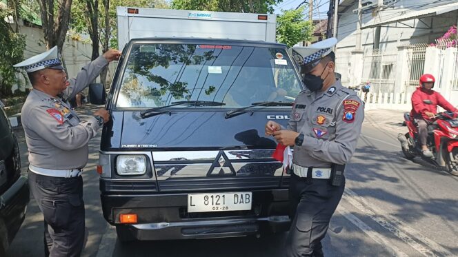 
					BAGI BENDERA: Anggota Satlantas Polres Probolinggo Kota saat membagikan bendera merah putih ke pengguna kendaraan. (foto: istimewa)
