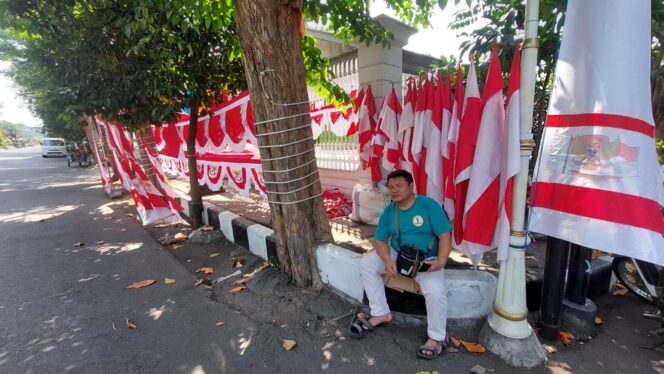 
					MUSIMAN: Penjual bendera di Jalan Panglima Sudirman, Kota Probolinggo, Mansyur, tengah menunggu pembeli. (foto: Hafiz Rozani).