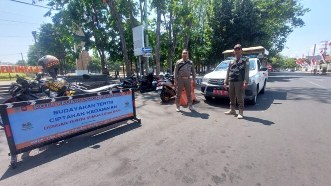 
					DITUTUP: Petugas Satpol PP Kota Probolinggo berjaga di area alun-alun untuk mencegah pedagang berjualan. (foto: Hafiz Rozani).