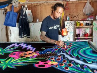 Rachmad dengan karyanya, batik fosfor. (Foto: Istimewa.)