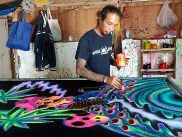 Rachmad dengan karyanya, batik fosfor. (Foto: Istimewa.)