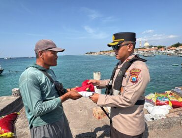 BERBAGI: Kapolres Probolinggo, AKBP M. Wahyudin Latif saat memberikan bendera merah putih kepada nelayan Pulau Gili Ketapang. (foto: Bag. Humas Polres Probolinggo).