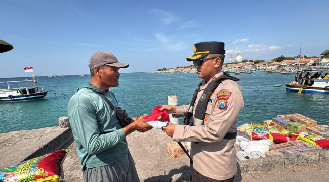 BERBAGI: Kapolres Probolinggo, AKBP M. Wahyudin Latif saat memberikan bendera merah putih kepada nelayan Pulau Gili Ketapang. (foto: Bag. Humas Polres Probolinggo).
