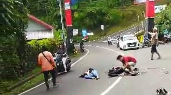 Dua pengendara motor tergeletak di jalan usai menabrak dump truck di Jalan Prigen-Pandaan (Foto: Tangkapan layar video amatir milik warga)